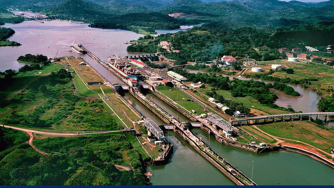 Aerial view of the Panama Canal with cargo ships navigating through locks. A critical artery for global trade that connects the Atlantic and Pacific Oceans